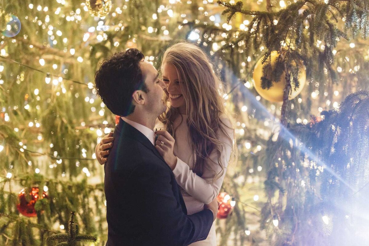 winter wedding bride and groom with christmas tree