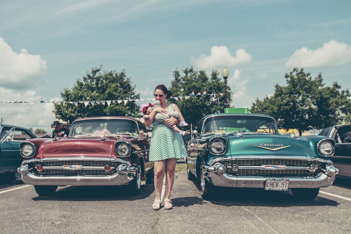 retro photo of mother and baby near classic cars