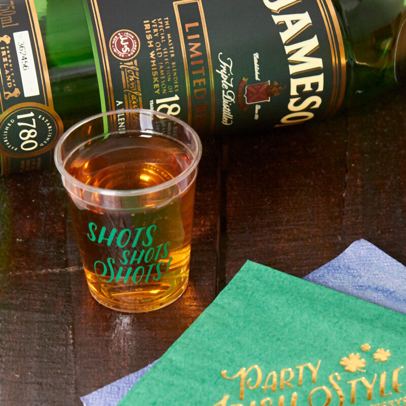 shot glass with a bottle of whiskey in the background