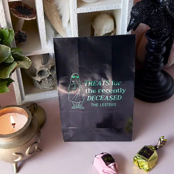 Treats For The Recently Deceased Bag aside lit candle and treats