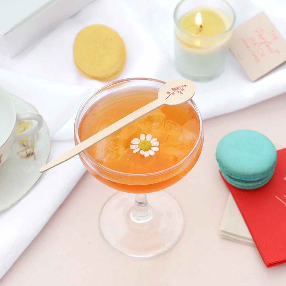Floral Stir Stick laying across a cocktail glass