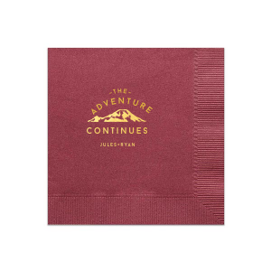 The Adventure Continues Napkin design encapsulates the spirit of exploration and shared journey. Featuring a graphic of snow-capped mountains with "The Adventure" arching over and "CONTINUES" below, it symbolizes the ongoing journey of the couple. Their names personalize this narrative of continuous adventure and discovery as they embark on life together. 