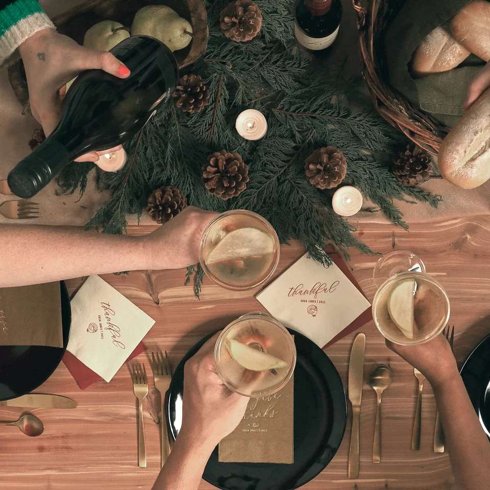 Hands cheering glasses around a festive table 