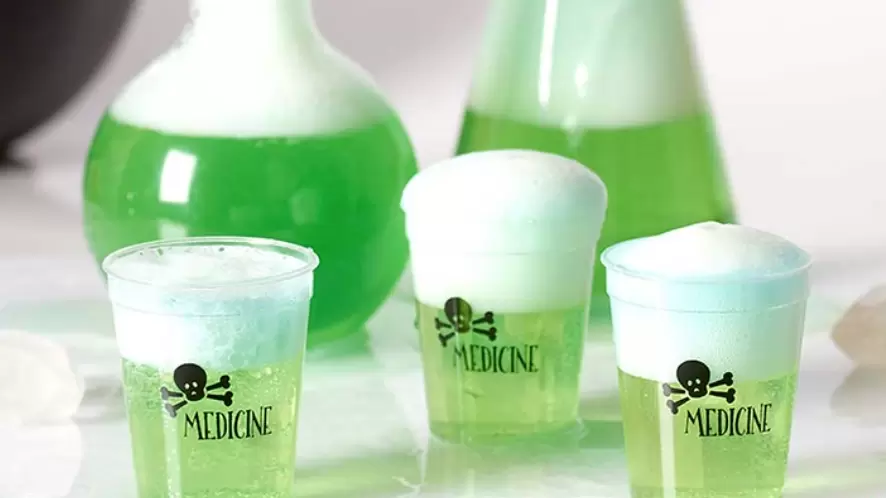 Shot glasses that say "Medicine" filled with a green foamy liquid.