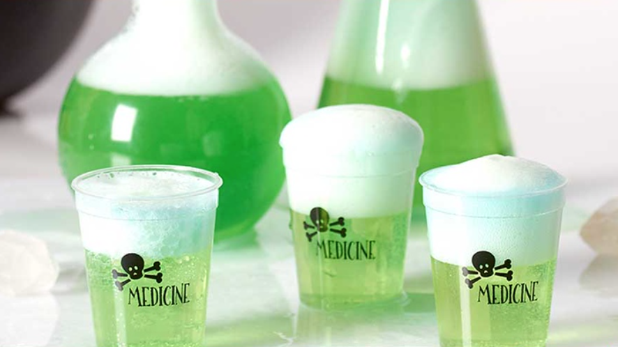 Shot glasses that say "Medicine" filled with a green foamy liquid.