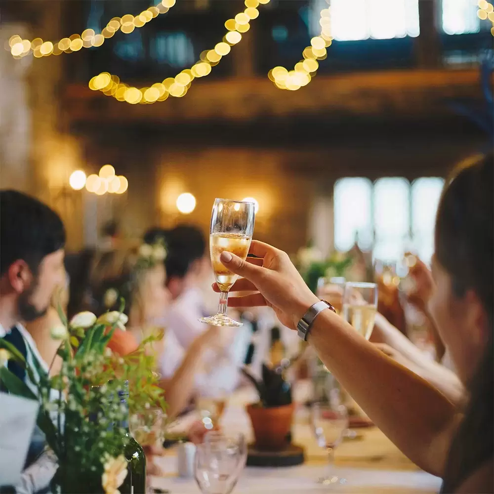 raising a champagne glass in a toast at a wedding dinner credit Al Elmes