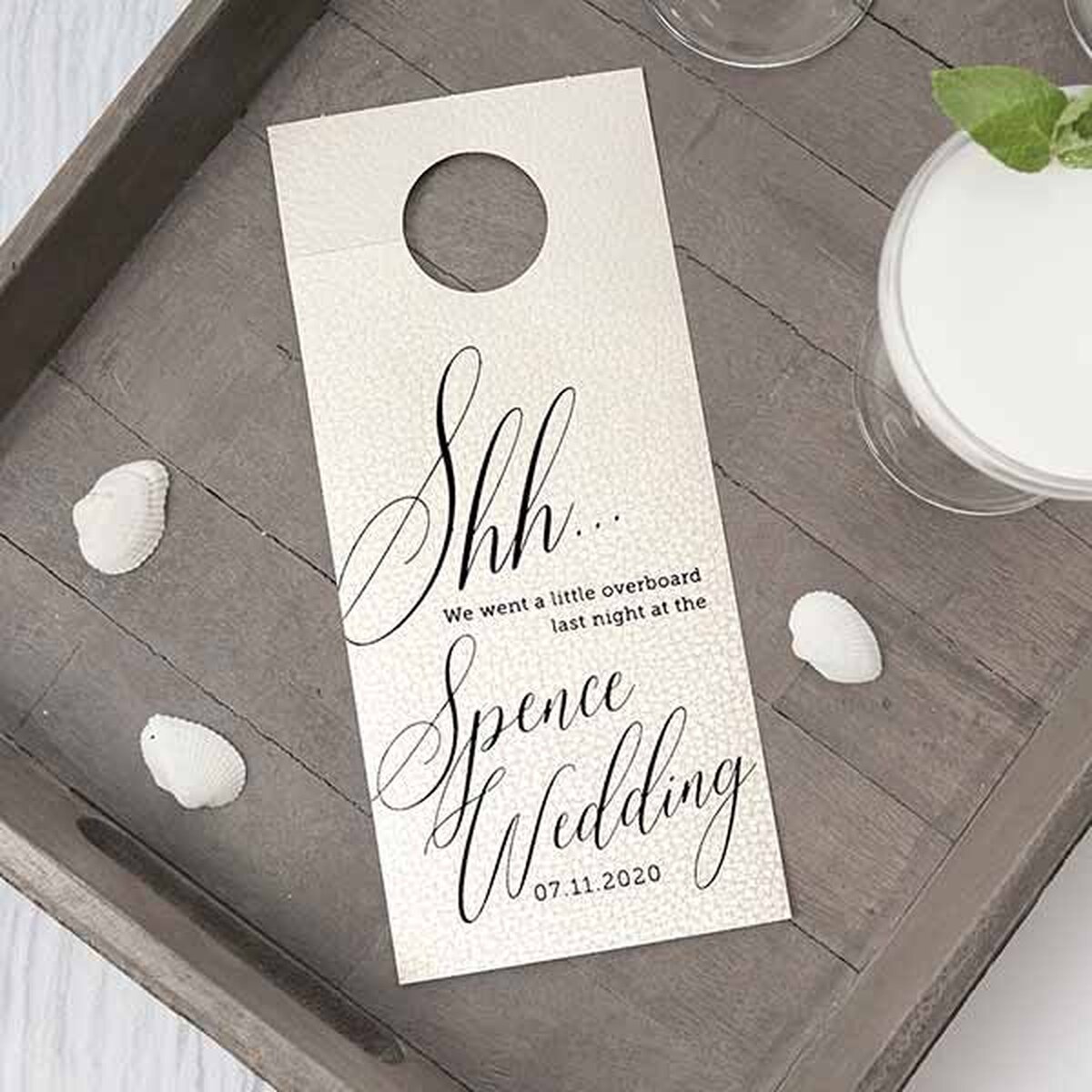 Leather like pearl door hangers with matte black foil design on a tray with petals