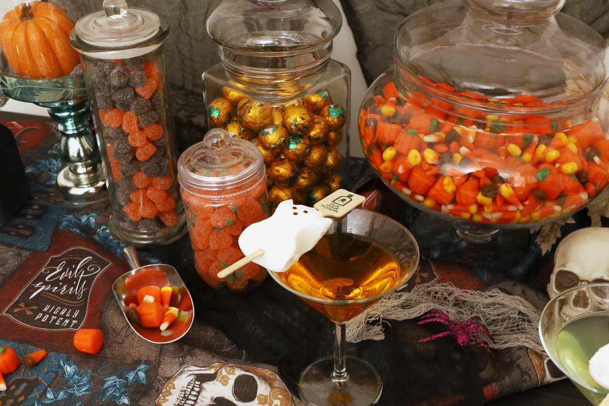 Halloween candy buffet with candy corn martini placed in front of it. 