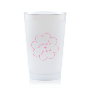 Sip in style at your whimsical wedding with the Kitschy Cocktail Hour Floral Frame Cup. Personalize this charming vessel with the couple's names, elegantly scripted within a blooming flower-shaped frame. A modern and enchanting choice for your celebratory toasts.
