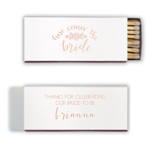 Ignite the bridal shower buzz with the Here Comes The Bride Matchbox, adorned with a floral garland that sings of upcoming vows. Above the bride's sweetly scripted name, a message of gratitude adds warmth to the pre-wedding celebration.