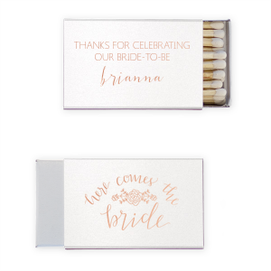 Ignite the bridal shower buzz with the Here Comes The Bride Matchbox, adorned with a floral garland that sings of upcoming vows. Above the bride's sweetly scripted name, a message of gratitude adds warmth to the pre-wedding celebration.
