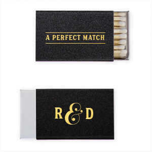 The A Perfect Matchbox design exudes elegance with its club-like vibe. ‘A PERFECT MATCH’ is boldly framed as a sophisticated statement of fact. The side panel playfully presents the couple’s initials in bold block letters, linked by a shadowed, 3D-styled ampersand. A design blend of classic and creative.