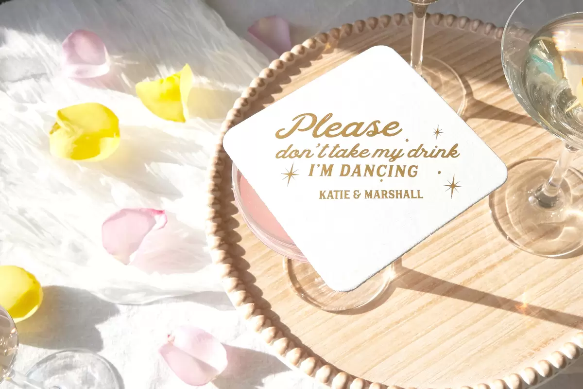 White coaster on top of a drink that says "please don't take my drink, I'm dancing"