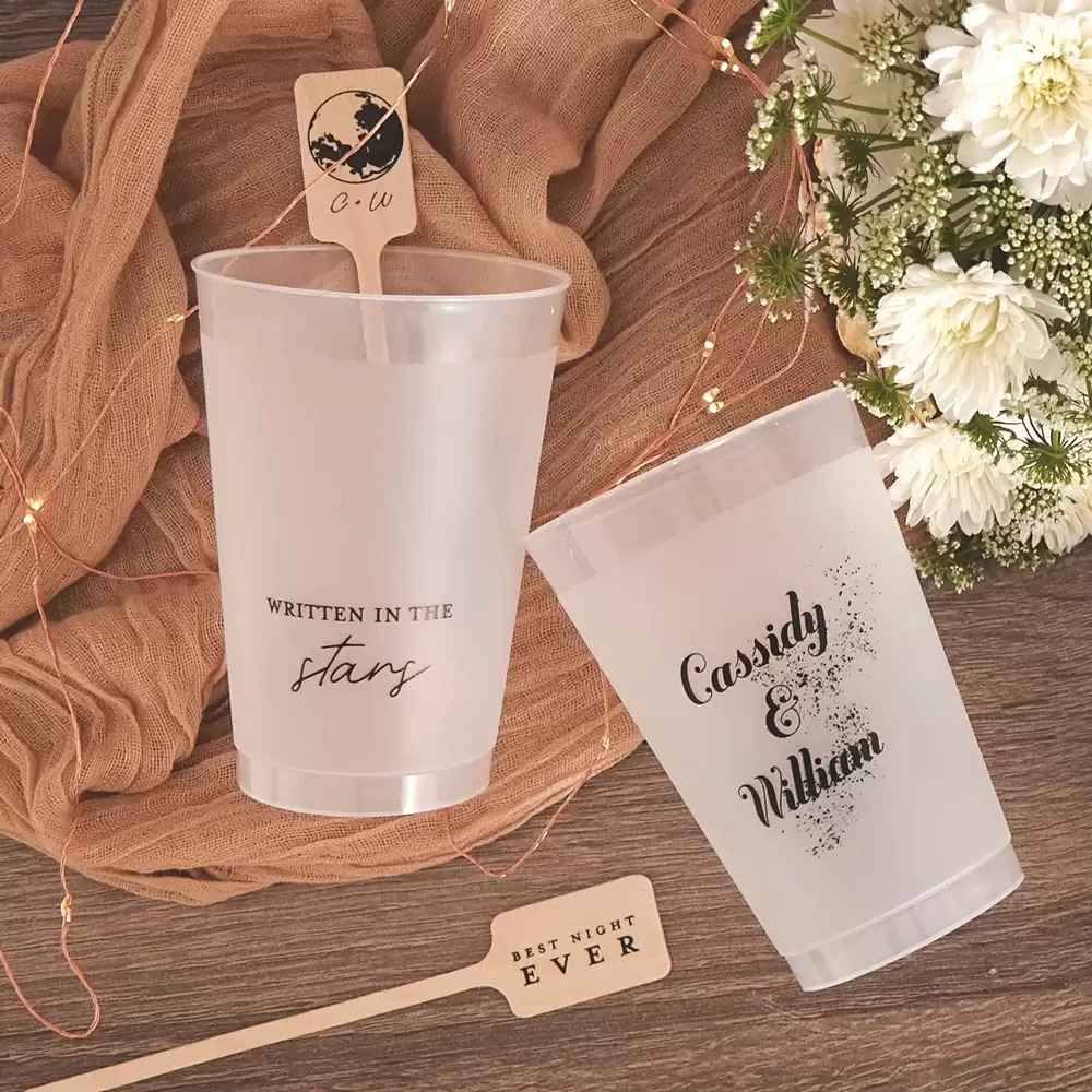 arrangement of custom cups and stir sticks with flowers and fairy lights