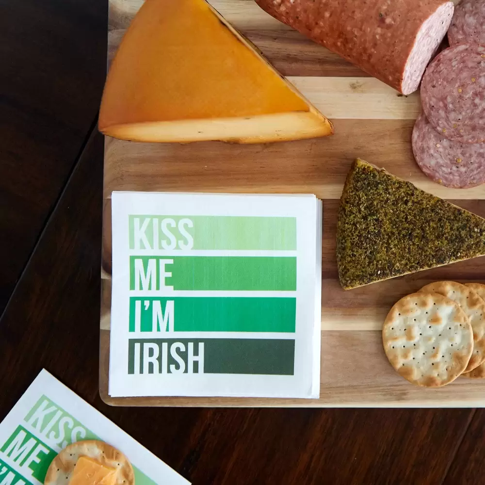 a green napkin on a cutting board with meat and cheese