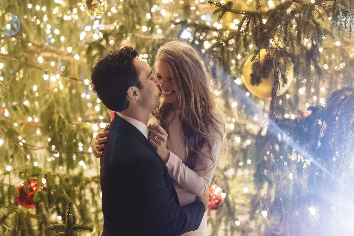 winter wedding bride and groom with christmas tree