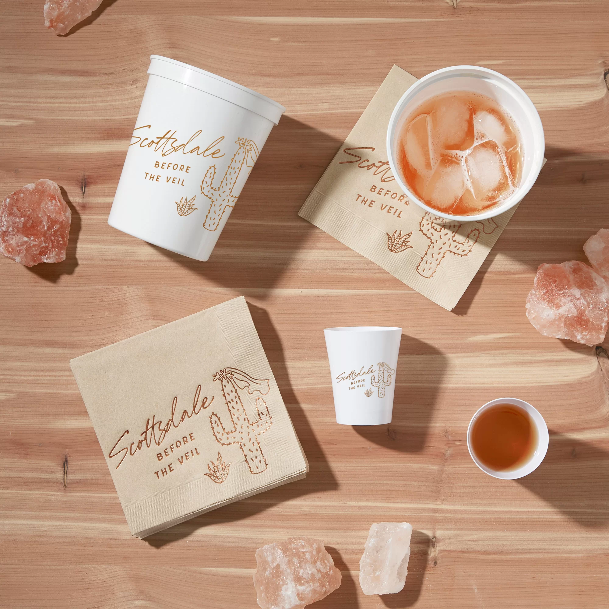 Cup, shot glass and napkin styled on a wood table