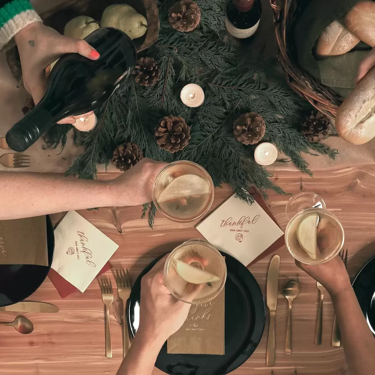 Hands cheering glasses around a festive table 