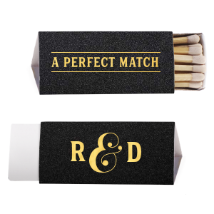 The A Perfect Matchbox design exudes elegance with its club-like vibe. ‘A PERFECT MATCH’ is boldly framed as a sophisticated statement of fact. The side panel playfully presents the couple’s initials in bold block letters, linked by a shadowed, 3D-styled ampersand. A design blend of classic and creative.