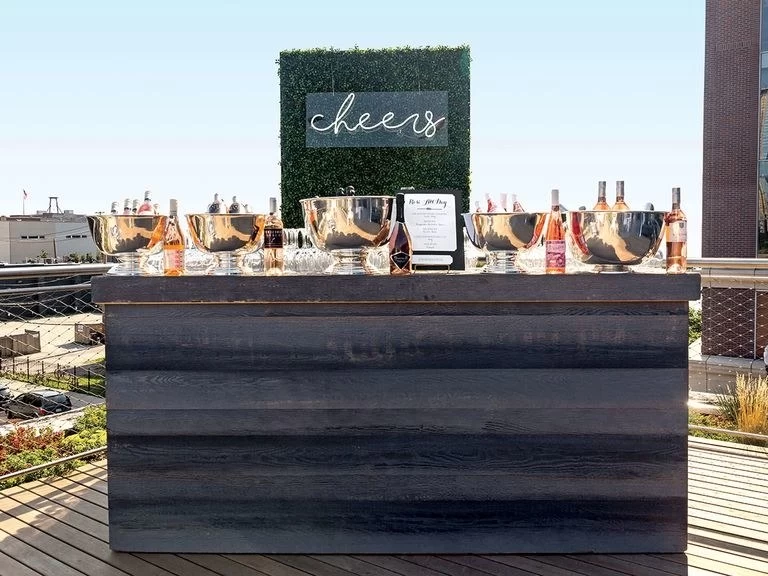 outdoor wedding reception bar with custom neon wedding sign saying "cheers"