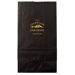 The Adventure Continues Bag encapsulates the spirit of exploration and shared journey. Featuring a graphic of snow-capped mountains with "The Adventure" arching over and "CONTINUES" below, it symbolizes the ongoing journey of the couple. Their names personalize this narrative of continuous adventure and discovery as they embark on life together. 