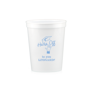 Celebrate the graduate's achievement with the Cap Toss Cheers Grad Cup, adorned with a hand throwing a graduation cap and the encouraging phrase "Hats off to you," alongside the name of the graduate. A personalized tribute to their hard work and bright future.