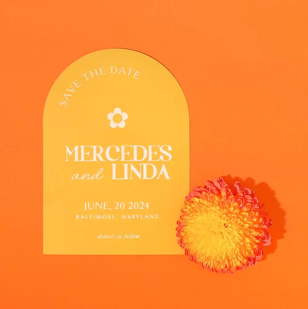 Stack of three wedding arch invitations with an orange flower