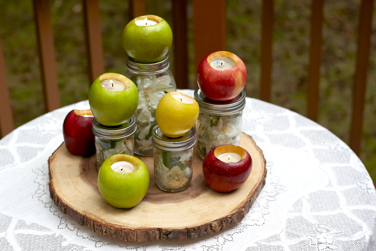 fall centerpiece with apples, flowers and diy votive candle holders
