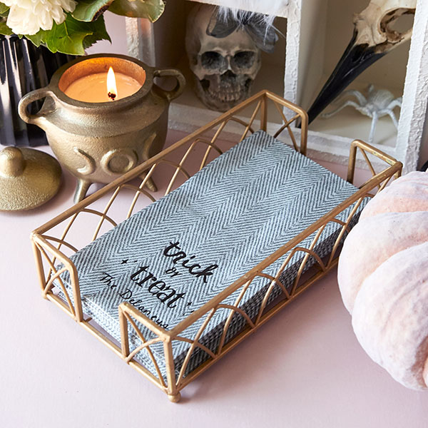 Starry Trick Or Trick Napkin placed in holder aside candle and pumpkin