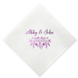 The Garden Flourish Napkin design exudes old-world romance. The couple's names are elegantly scripted in a swirling, romantic font. Below, a whimsical cascade of florals and greenery, dotted with hidden hearts and interspersed flowers, evokes the charm of a bride's cascading bouquet.