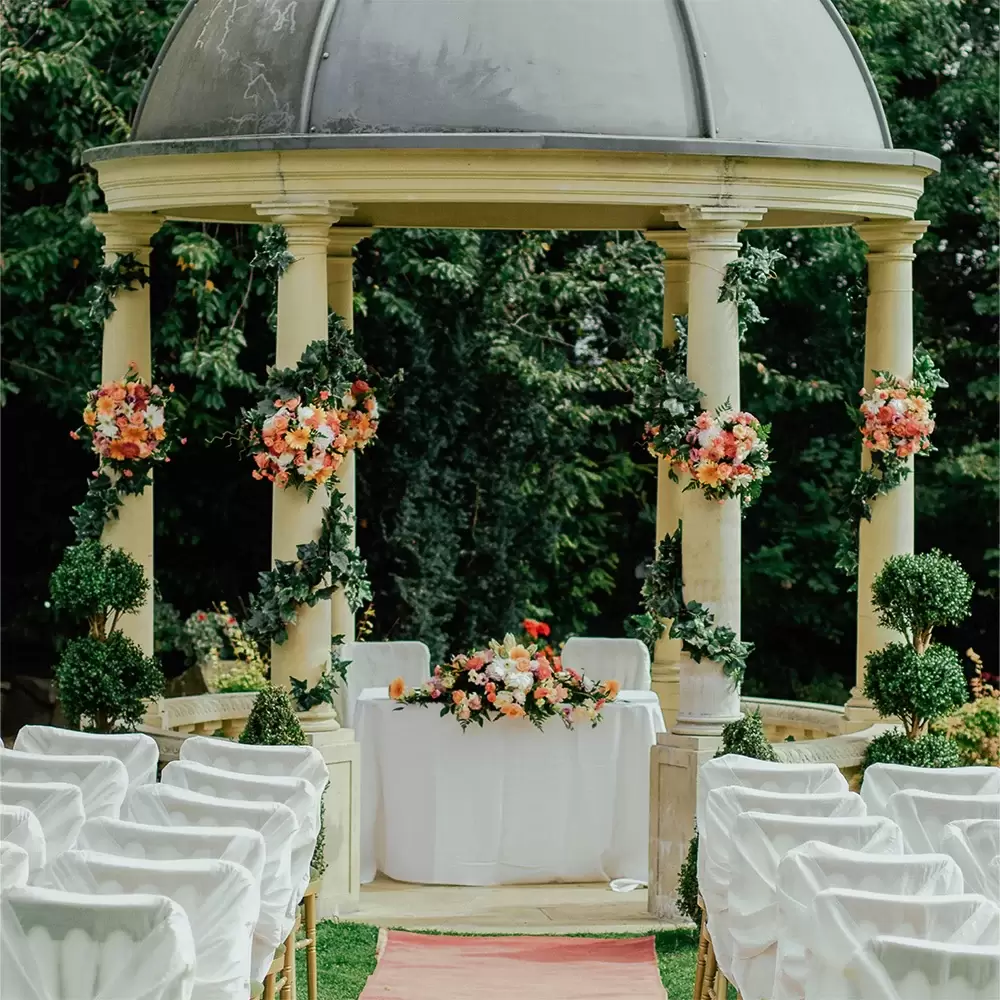 view looking down an aisle towards a table and chairs inside of a gazebo], credit Jeremy Wong Weddings.