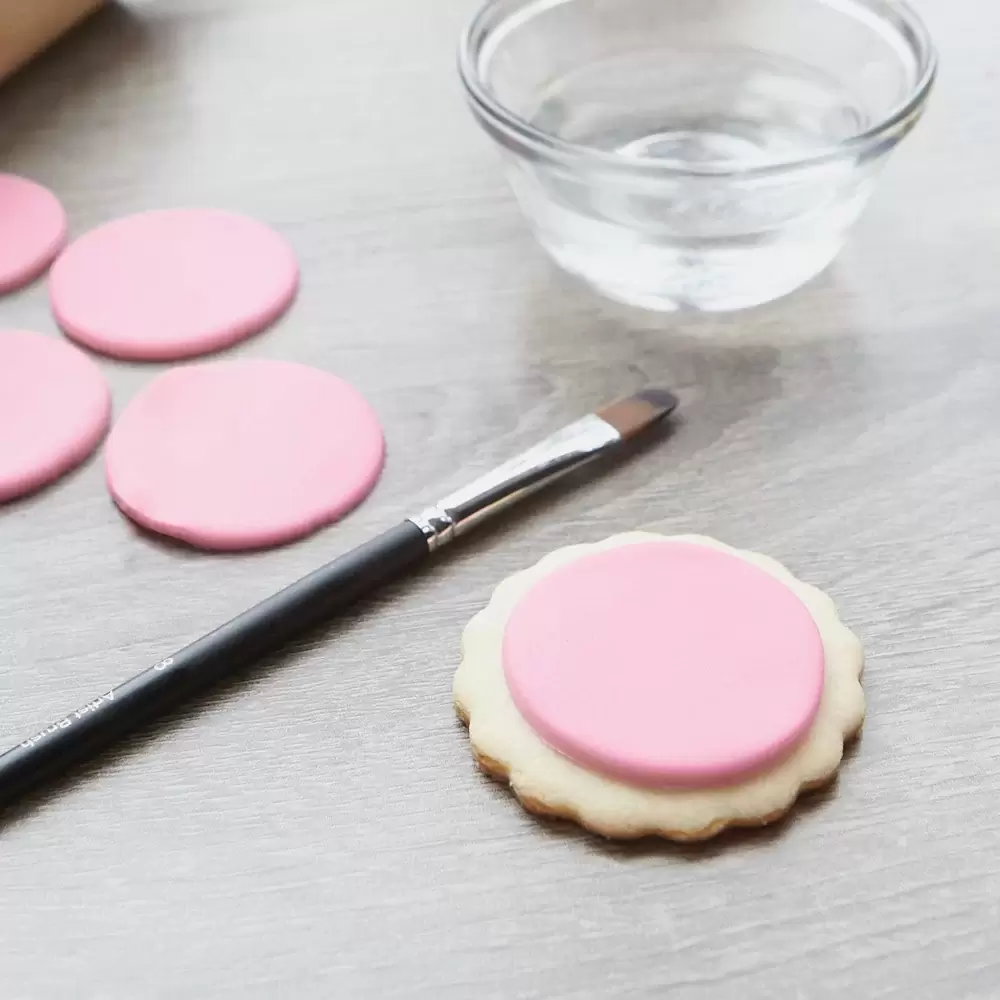 step two brush fondant and place on custom cookies