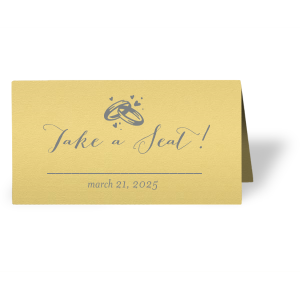 Customize place cards and impress guests with beautiful wedding details. This card leaves space for a name and table number, right under our classic Wedding Rings graphic and catchy calligraphy saying. Choose your theme colors and add your wedding date for a personal touch. 