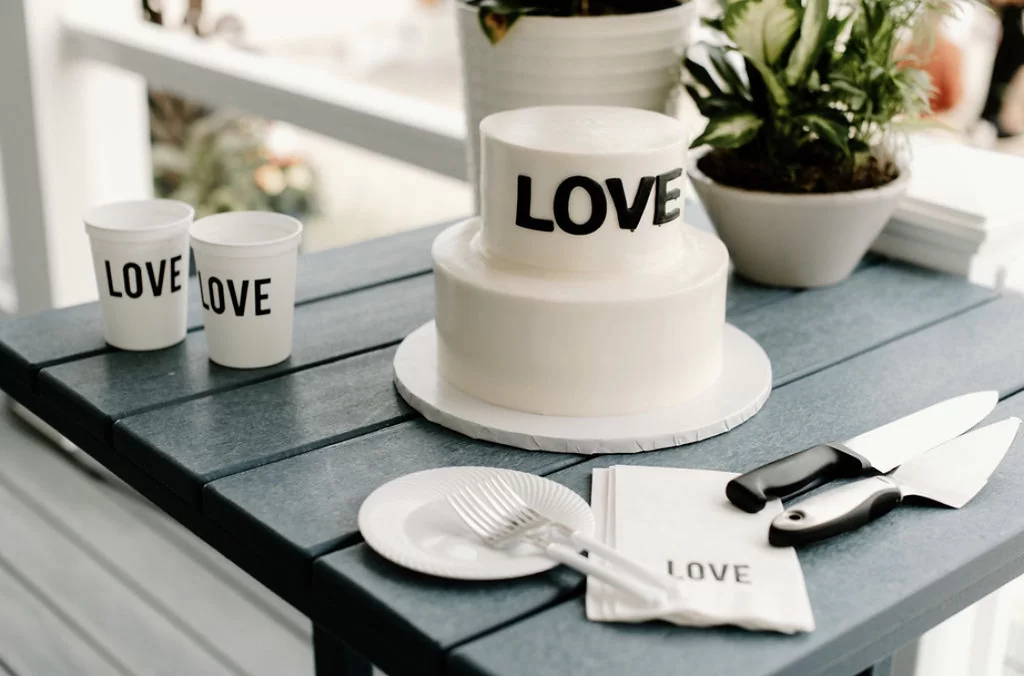 wedding table setting with white stadium cups and blank ink and white cocktail napkins with black foil