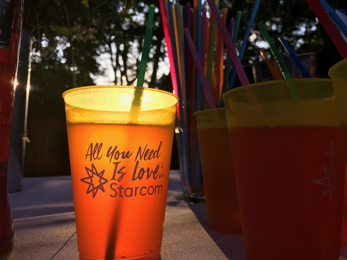 personalized plastic cups with colorful straws for an outdoor party