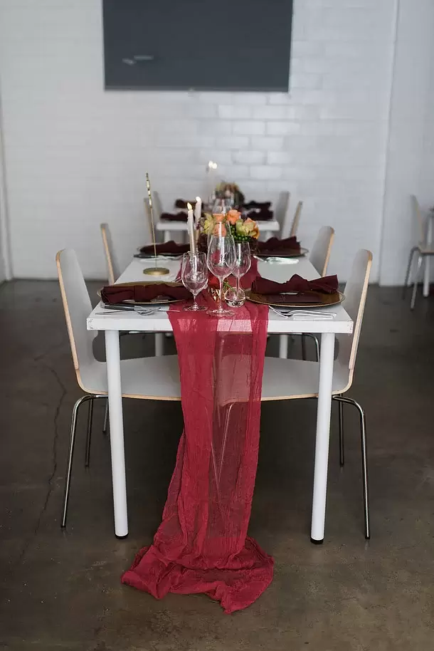 long table runner with red and maroon table decorations