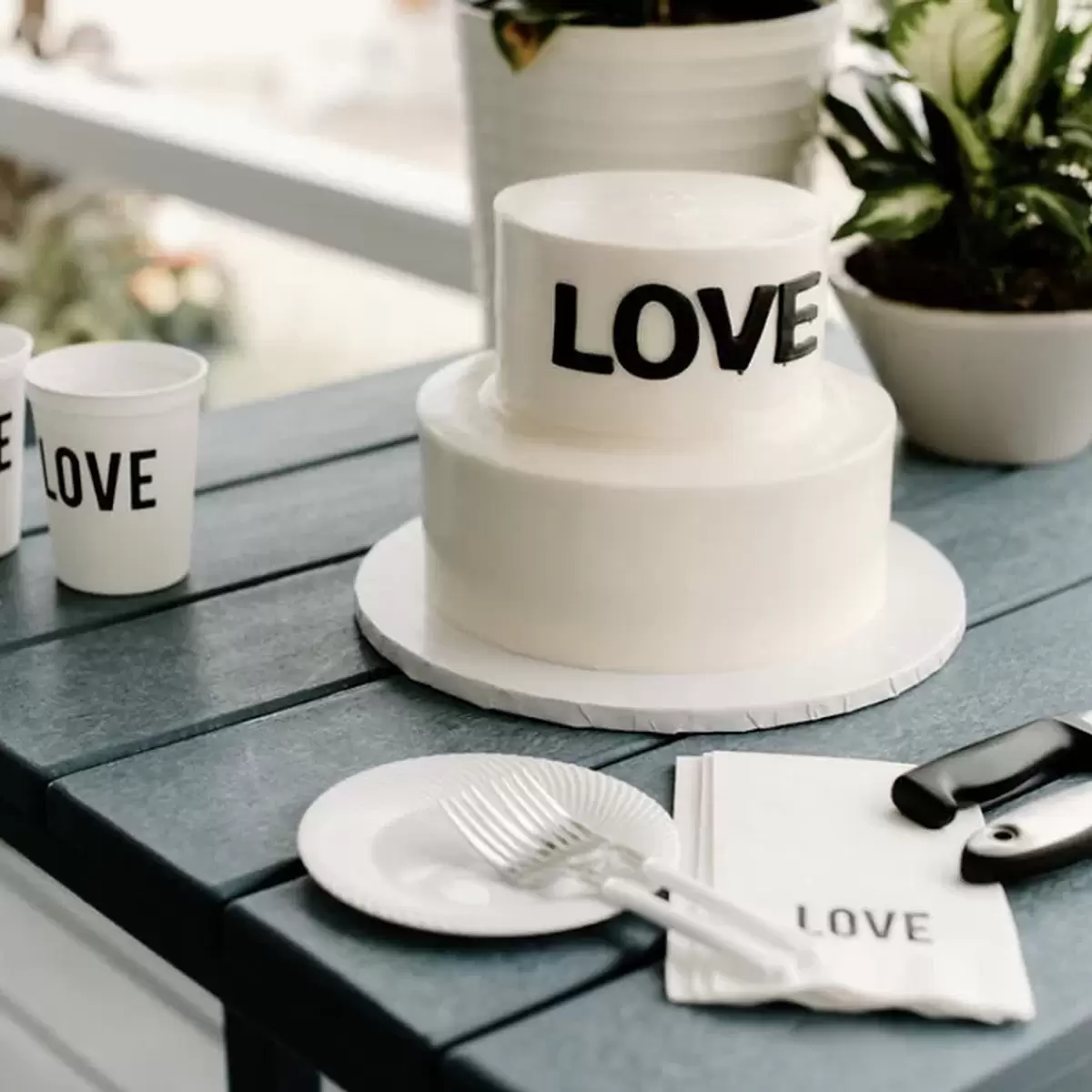 wedding table setting with white stadium cups and blank ink and white cocktail napkins with black foil